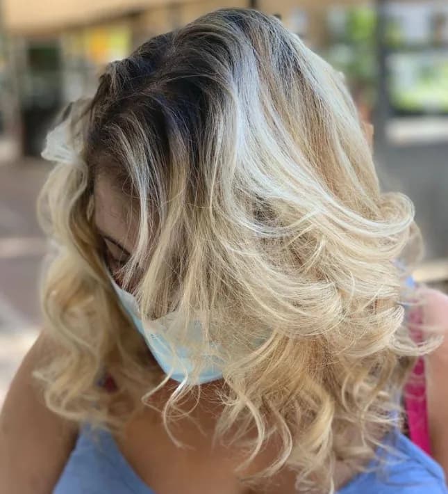 Capelli biondi mossi di media lunghezza, con la radice piu scura