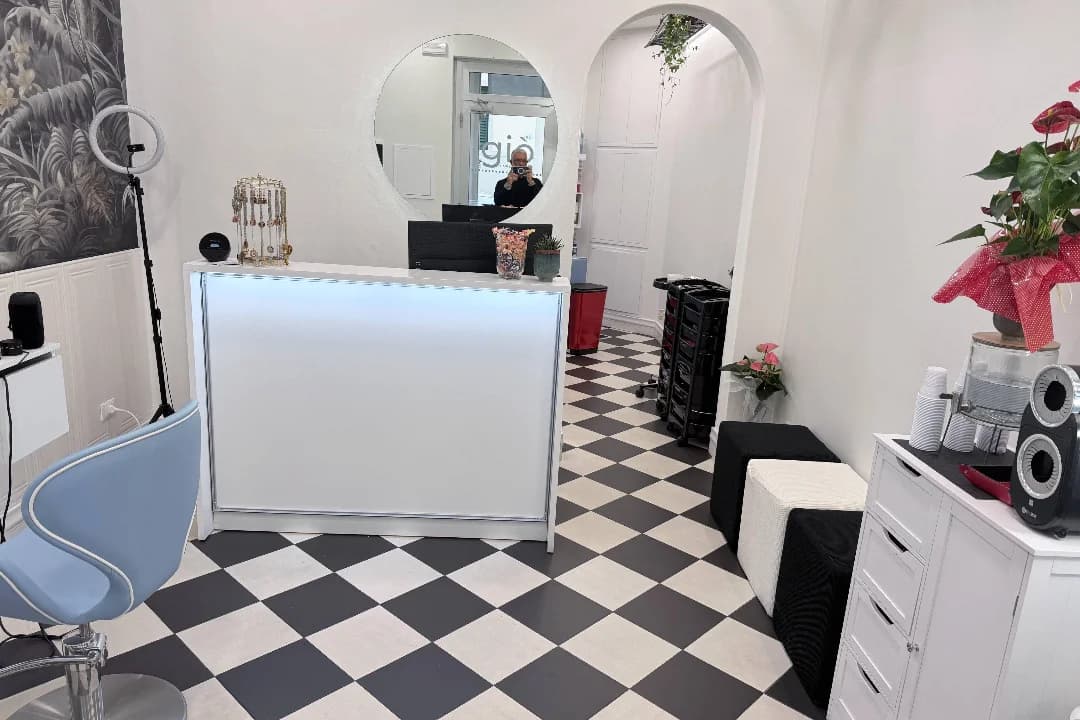 Il bancone della reception, con lo specchio tondo e il pavimento a scacchi